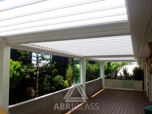 Terrasse aménagée avec pergola bioclimatique à lames orientables et panoramique en verre ouvert