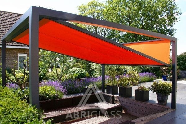 Aménagement de terrasse chez un particulier avec pergola à toile rétractable KUB orange