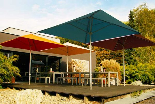 Plusieurs parasols BEACH en protection d'une terrasse bois