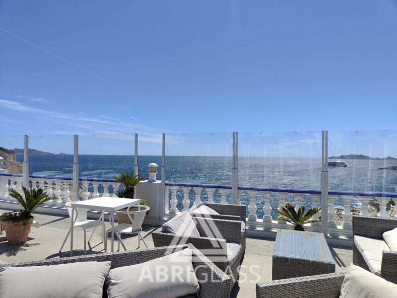 Paravent télescopique transparent sur une terrasse en bord de mer