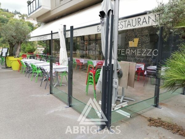 Paravent télescopique tout verre, installé sur terrasse de bar restaurant
