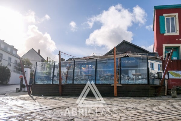 Terrasse face à la mer, abriée par paravent télescopique Fusion Abriglass